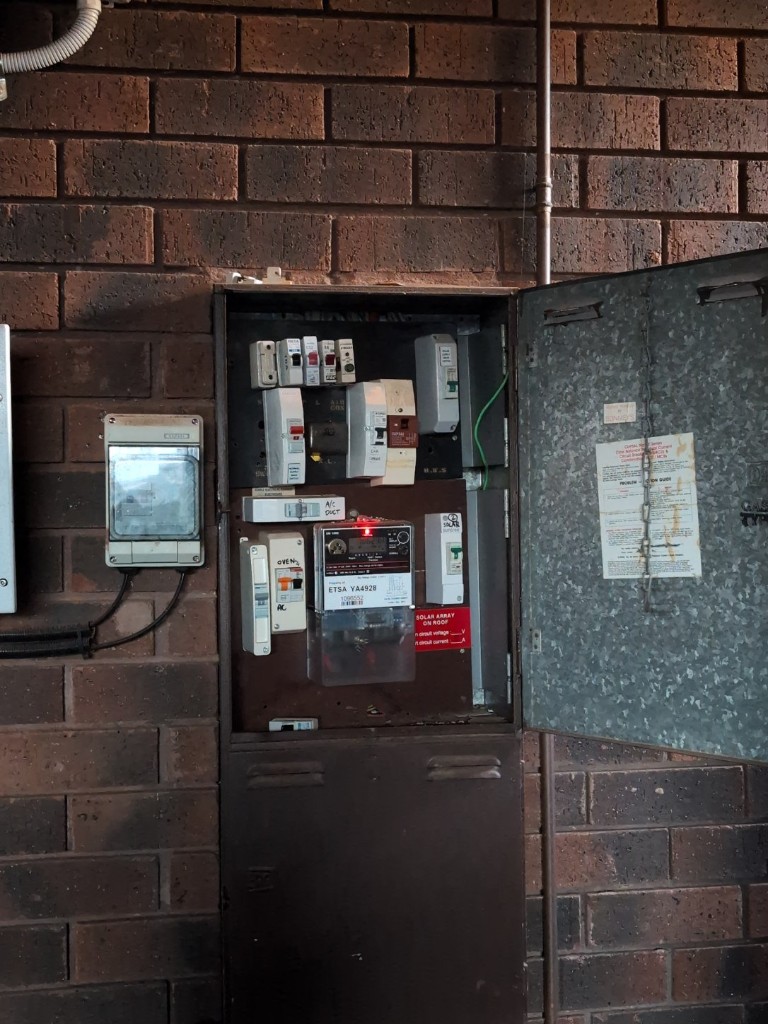 Board internal condition before rectification in an Adelaide home, showing older switchgear layout and mixed legacy protection.